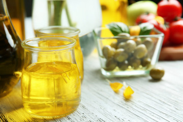 Jar with cooking oil on wooden table