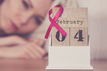 Woman on bed, world breast cancer day on calendar