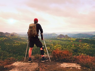 Man hiker Wearing Supportive Leg Brace and gainst the cruthes. Natural forest park
