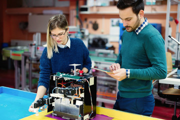 Fototapeta premium Young students of robotics preparing robot for testing