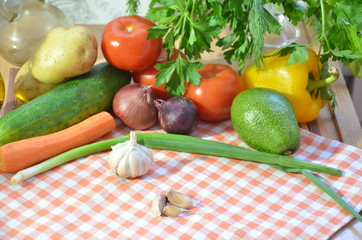 Fresh organic raw vegetables on a table. Garlic tomatoes green parsley potatoes yellow sweet pepper avocado onions