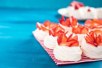 A small meringue Pavlova dessert with some strawberry slices