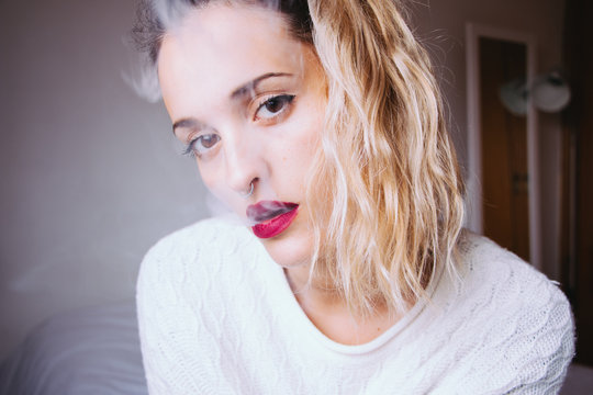 Portrait of a woman blowing smoke