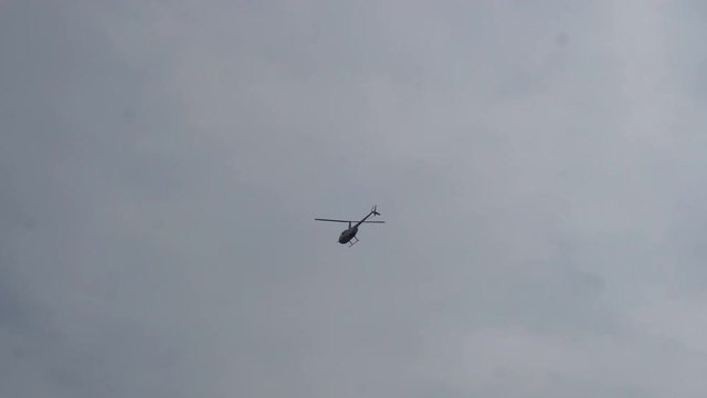 helicopter flying over the earth on a background of clear sky.