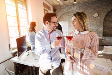 Happy young architects having break and drinking wine