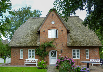 Fototapeta na wymiar Old house with a thatch on the German island of Foehr (Föhr)