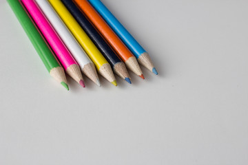 Close-up of a group of multicolored pencils on a white background