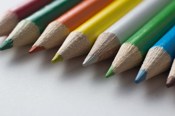 Close-up of a group of multicolored pencils on a white background