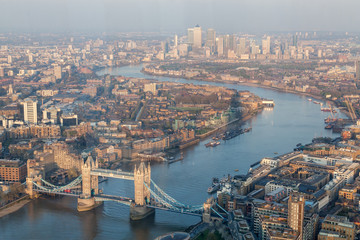 a view of Thames river and London at sunset with red sky and air pollution with Tower bridge