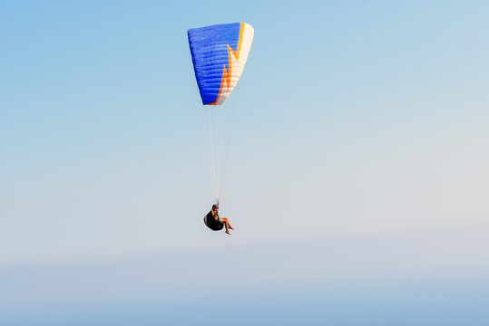 Flying paratrooper with full color parachute, isolated on a blue sky near Rhodes island, Greece