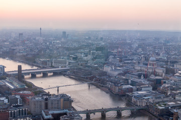 Fototapeta premium a view of Thames river and London at sunset with red sky and air pollution