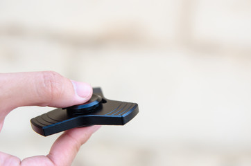 Playing with a Black Fidget Spinner. Metal spinner