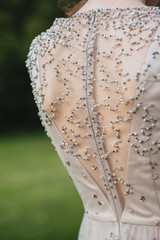 Women's back in a beautiful dress with a cut and embroidery of beads