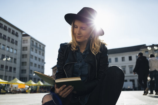 Fashionable woman reading a book outdoor