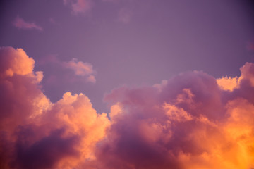 Magnificent colorful clouds in the evening sky. Bright, pink clouds in the sky at sunset. Beautiful evening skyscape. Abstract, purple pink background. Vibrant color photograph.
