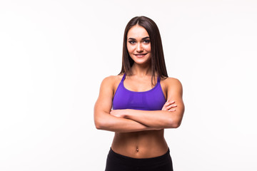 Smiling sports woman standing with arms folded and looking at camera isolated on a white background