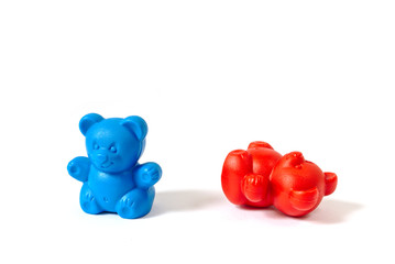 Blue plastic toy bear standing with red bear knocked over