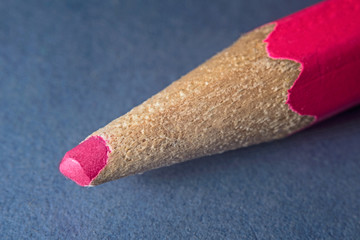 Part pink pencil macro on a blue background