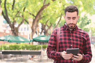 Fototapeta premium Young latin man using a tablet