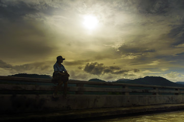 Fototapeta premium Traveler woman sitting on the bridge with backpack.