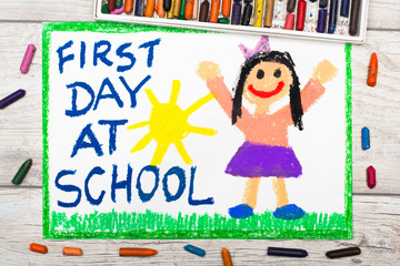 Obraz na płótnie Canvas Photo of colorful drawing: Words FIRST DAY AT SCHOOL and happy girl.