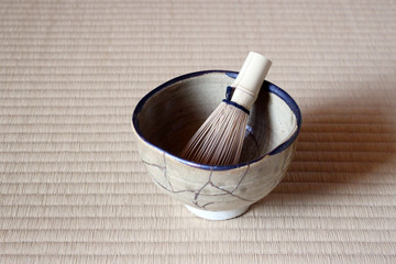 畳に置かれた金継された抹茶の茶碗と茶筅
