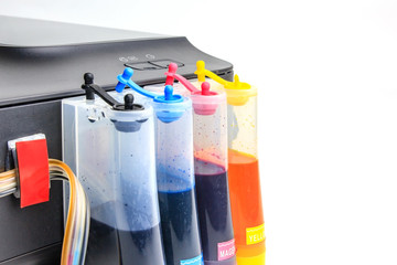Setting up modified ink tank for inkjet printer. Printer color ink tank beside isolated on white...