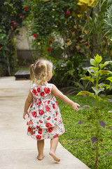 Child in the garden / Little girl is waslking in the garden