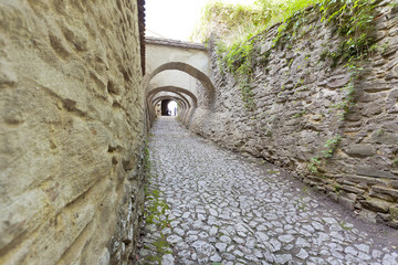 Medieval passage with buttresses and cobble stones 