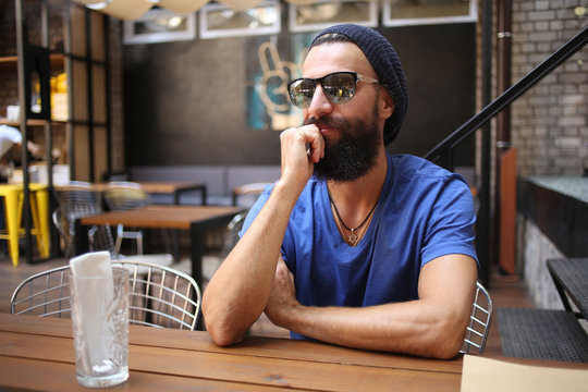 Bearded man with sunglasses in cafe