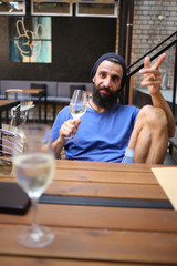 Guy with wine in cafe gesticulating