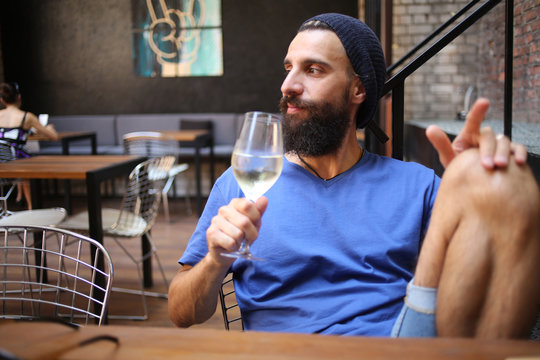 Bearded man with wine looking away