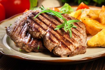 Succulent portions of grilled fillet mignon served with baked potatoes