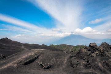 Volcanic rock formations at Pacaya Volcano, Guatemala with Volcano Aqua in background