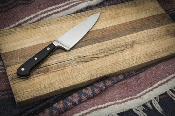 Wooden knife on grainy old fashioned cutting board with empty copy space for words.