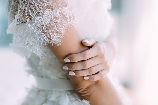 Elegant bride's hand with a white lace veil. Artwork Wedding concept. Close-up, soft focus