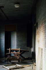 Fototapeta na wymiar Discarded Chair on Sun Porch - Abandoned House