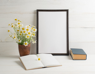 Daisy bouquet with open  notebook and motivational frame on background of  wooden planks in scandinavian style