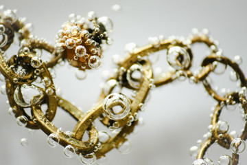 goldene Kette mit Perle in klarem Wasser mit Luftblasen