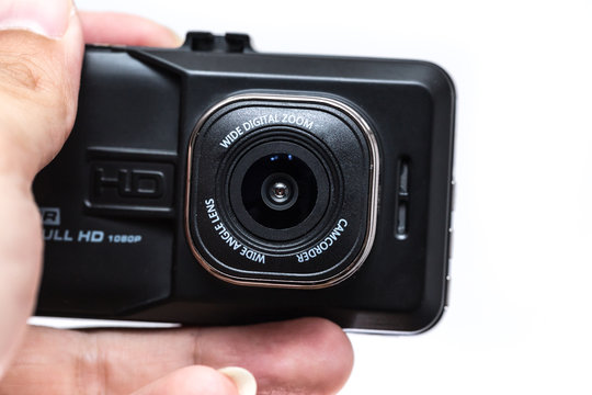 closeup digital camera action cam or dash cam show font lens in hand on white background