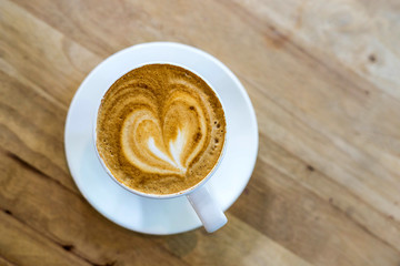 Hot art coffee cappuccino in a cup on wooden table background Top view with copy space