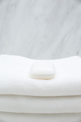 Fototapeta na wymiar All White Spa and Bath Image - Stacked Towels and Soap