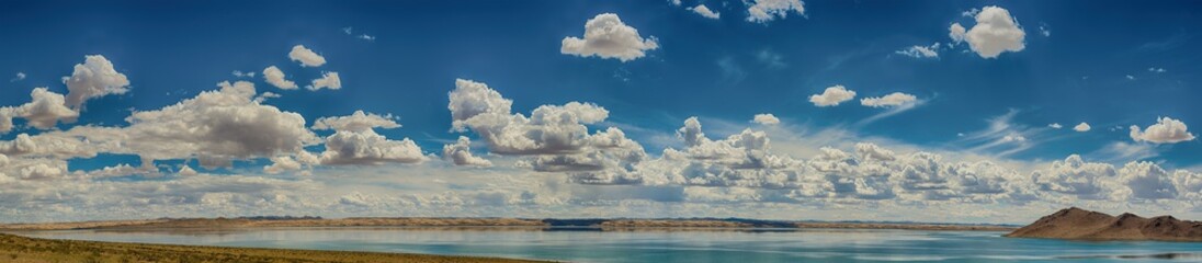 amazing fluffy white clouds in blue sky over ripple sea surface 
