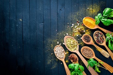 Various spices spoons on stone table. On a wooden board. Top view. Free space for your text.