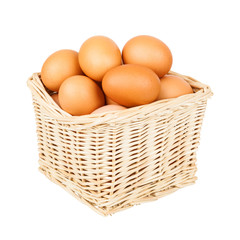 Wicker basket full of eggs isolated on white background close-up