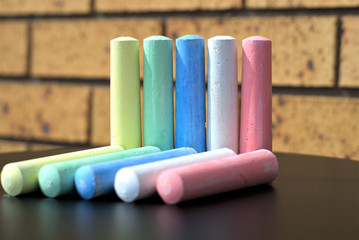 Pair of ten chalks of five different colors on table. Concept of ten as in ten things, ten objects, ten people of different colors.