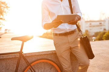 Handsome young african man early morning using tablet computer.