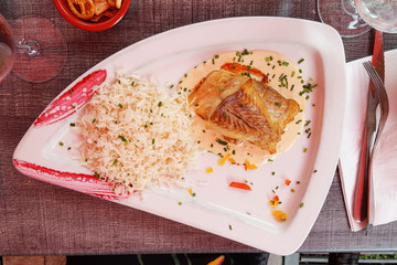 A plate in the restaurant with fish and rice