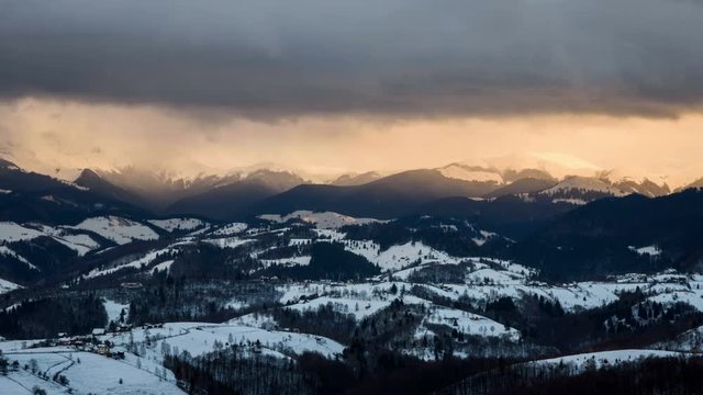 Yellow sky at sunset over mountainss and isolated houses. Transylvania, Romania.	Isolated houses in foreground and dynamic clouds over mountains in background. 4k timelapse.