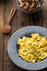 Plate of ravioli with mushroom on wood table

